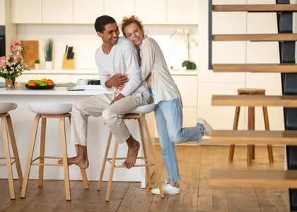 A couple laughing together in their kitchen